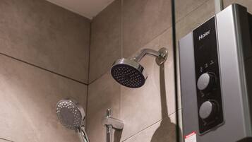 A modern bathroom with a shower head, a handheld shower, and a control panel.