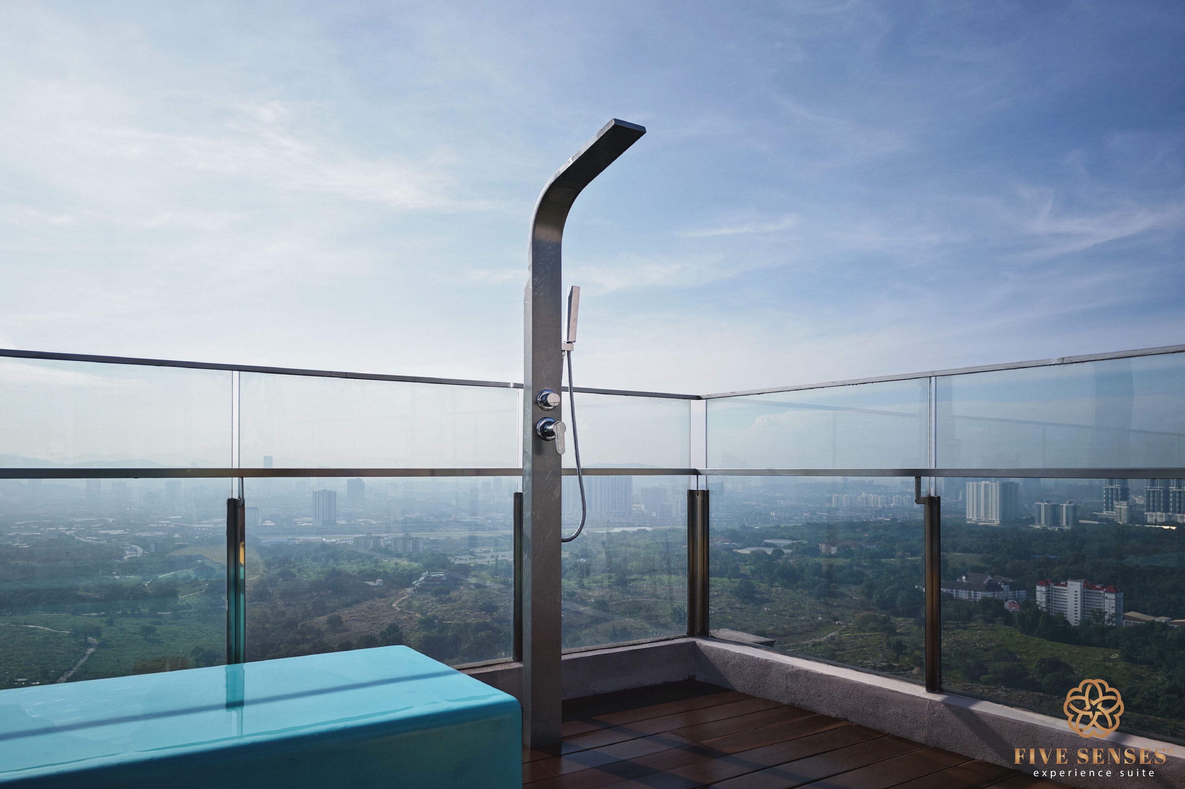 Un balcón moderno con barandilla de vidrio y vistas a la ciudad.