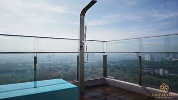 Un balcón moderno con barandilla de vidrio y vistas a la ciudad.