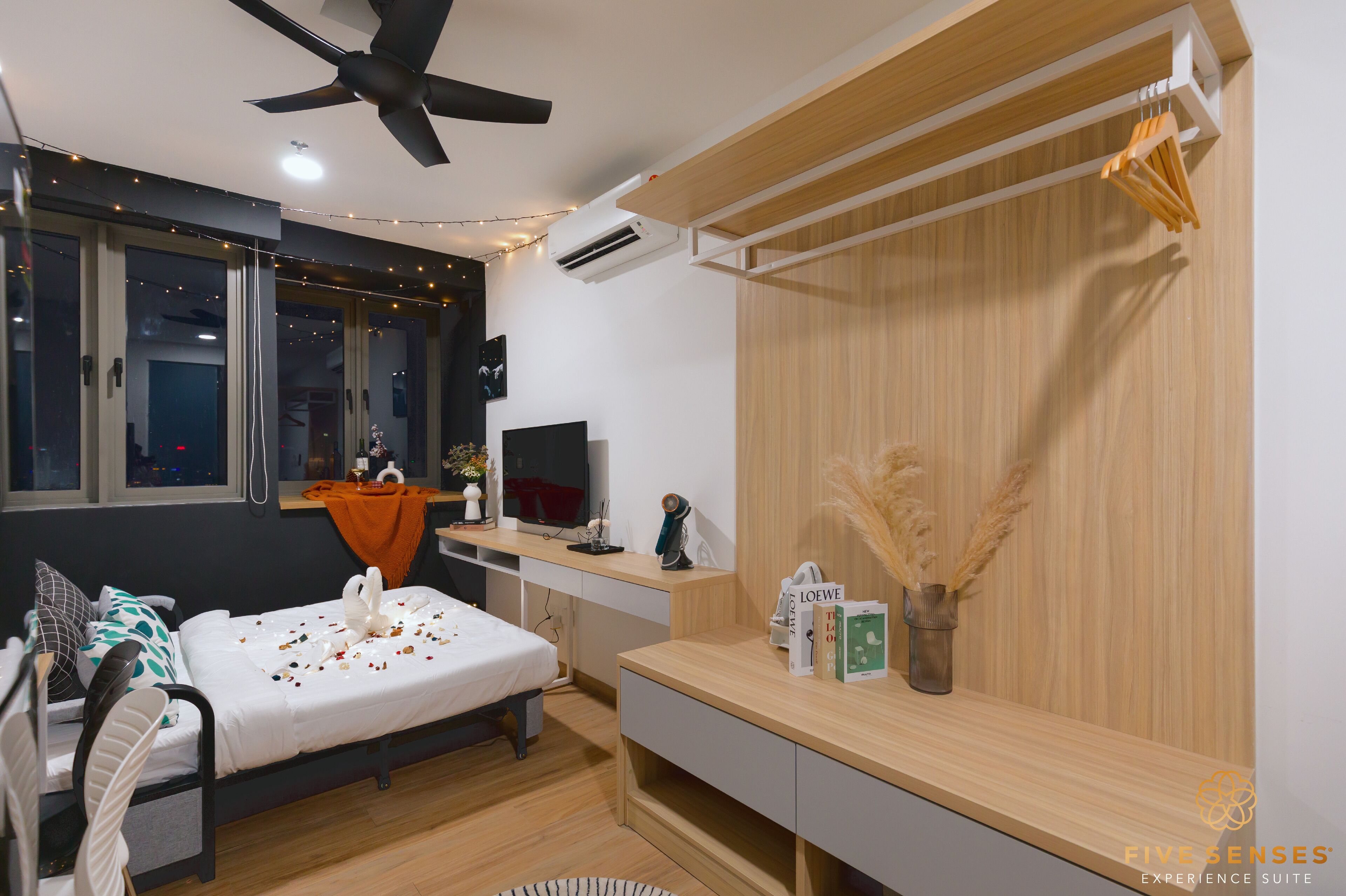 A modern bedroom with a bed, desk, and wardrobe.