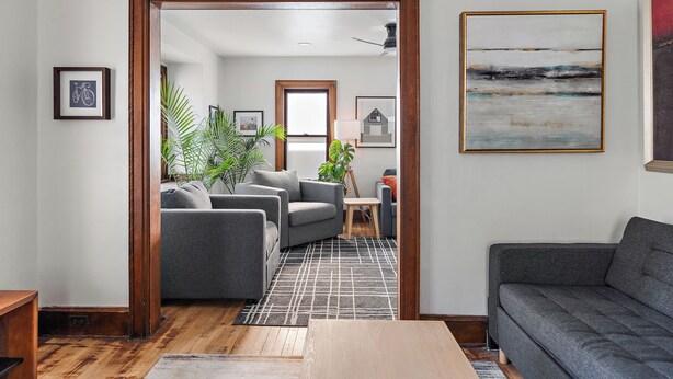 A modern living room with a grey sofa, a wooden coffee table, and a patterned rug. - NordEast Escape/Hot Tub, Bocce court, Fooseball, Patio, Awesome location (Minneapolis)