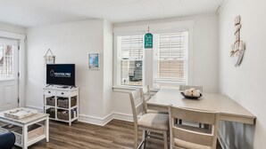 A modern living room with a television, a dining table, and a cozy seating area.