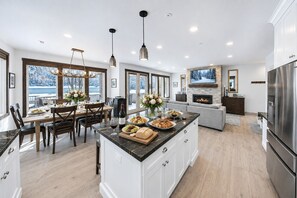 Una cocina moderna con una isla grande, comedor y chimenea.