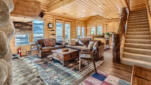 A log cabin interior with a cozy living area, wooden walls, and a staircase. - Deer Valley Escapes - Park City Ski Resort Condos (Park City)