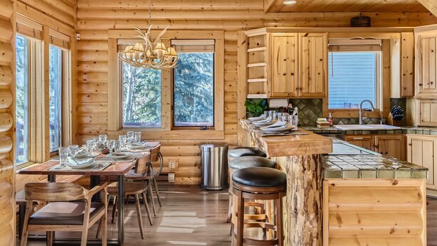 A log cabin interior with a dining area, kitchen, and bar. - Deer Valley Escapes - Park City Ski Resort Condos (Park City)