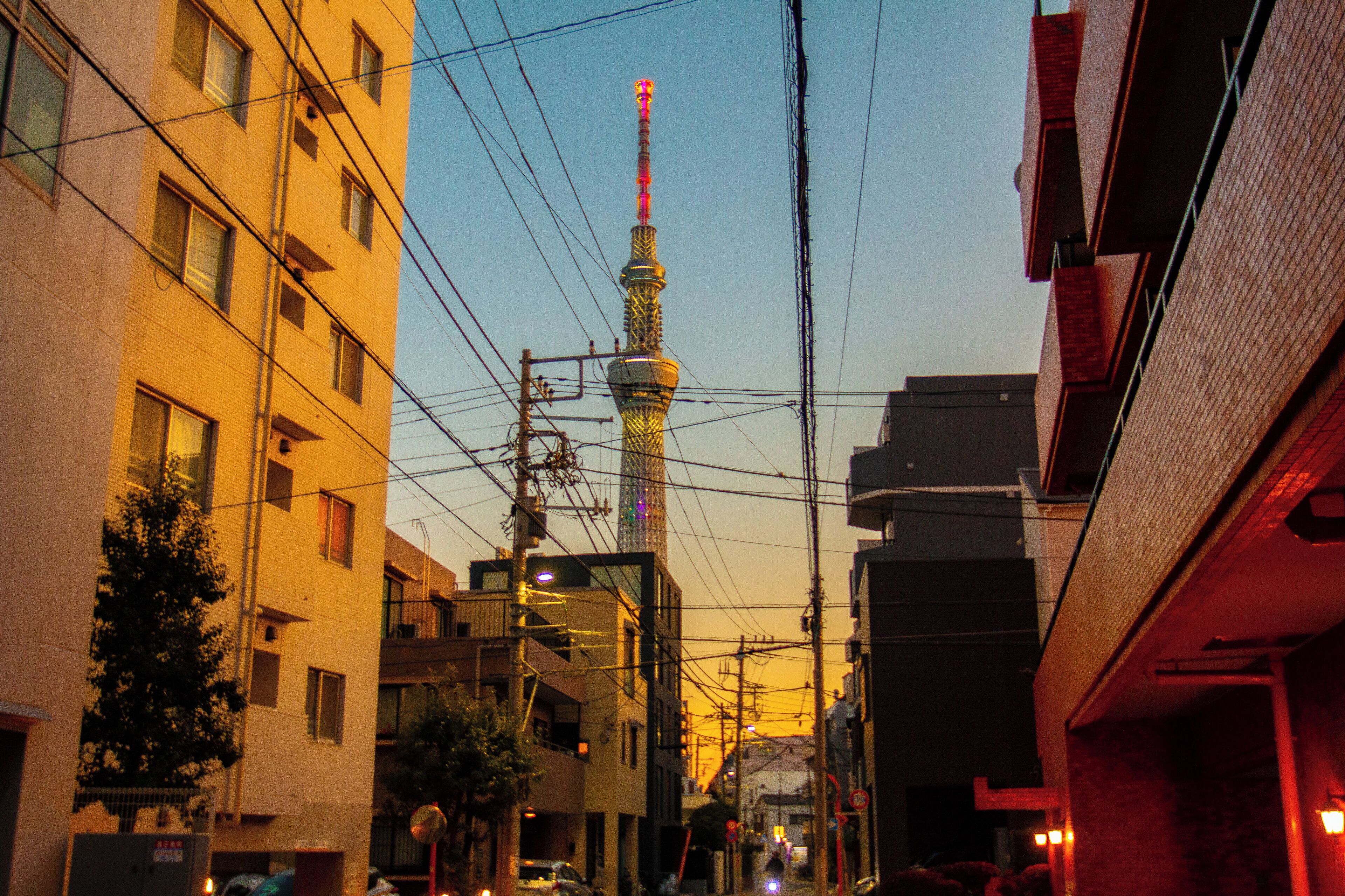 Una calle estrecha en la ciudad, con una torre destacada al fondo.