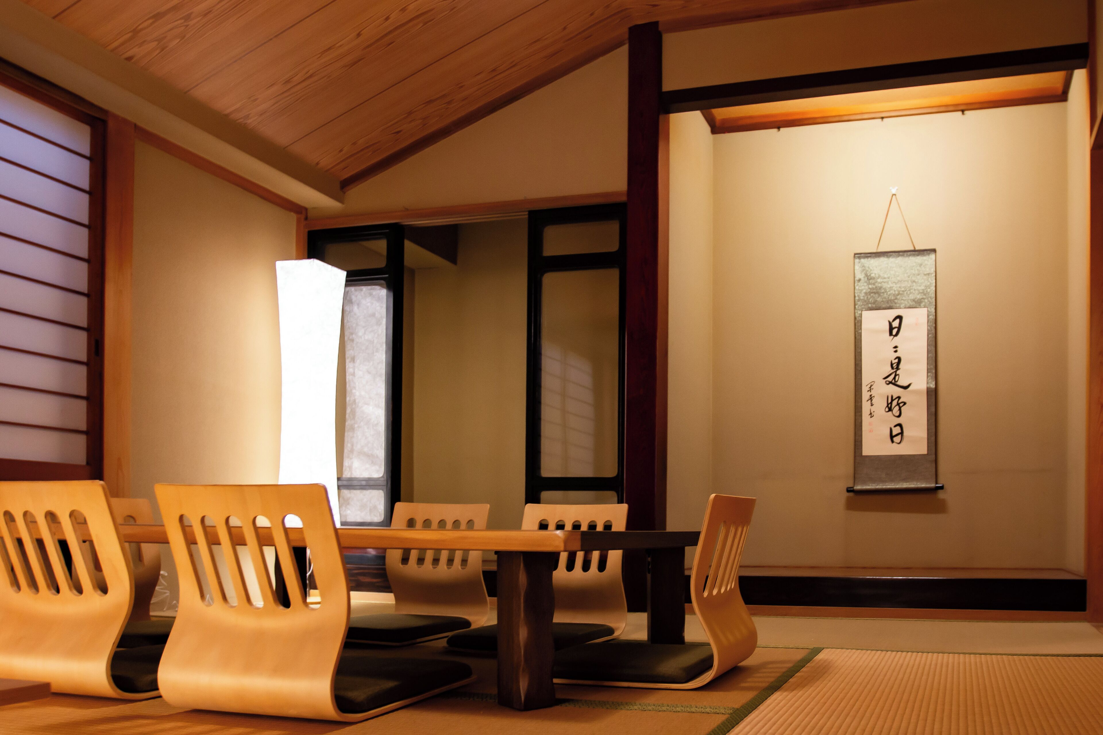 A traditional Japanese room with tatami flooring, wooden furniture, and a shoji screen.