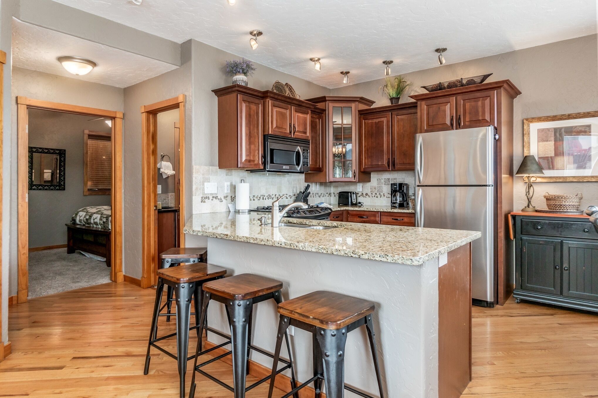 A modern kitchen with wooden cabinets, stainless steel appliances, and a granite countertop.