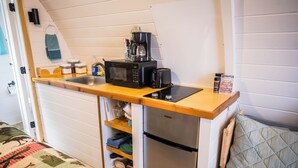 Une petite cuisine équipée d’un four à micro-ondes, d’une machine à café, d’un grille-pain et d’un petit réfrigérateur.