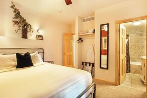 Enjoy a restful stay in this inviting room with a comfortable bed, modern bathroom, and a touch of greenery.