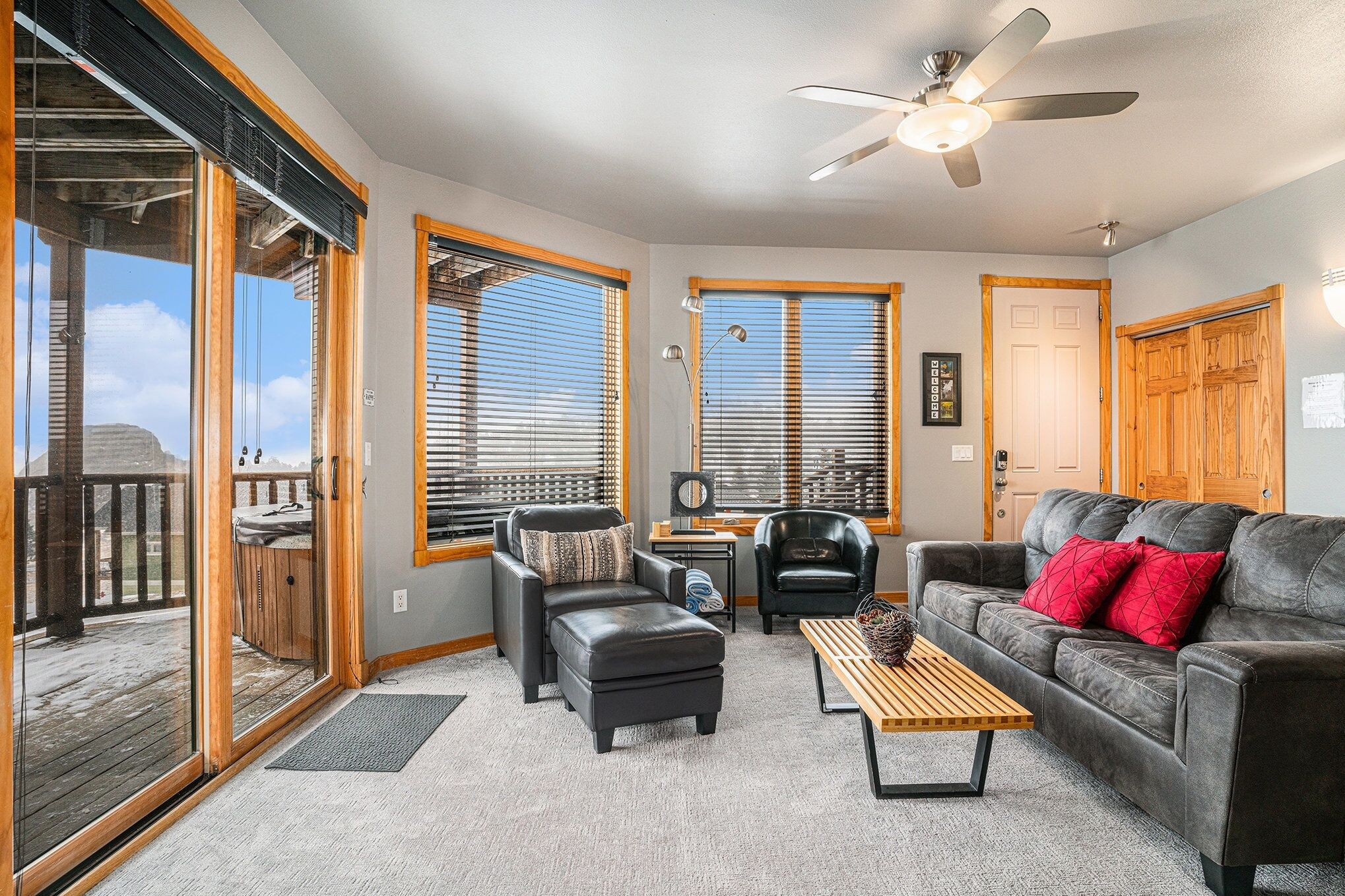 A cozy living room with a fireplace, comfortable seating, and large windows.