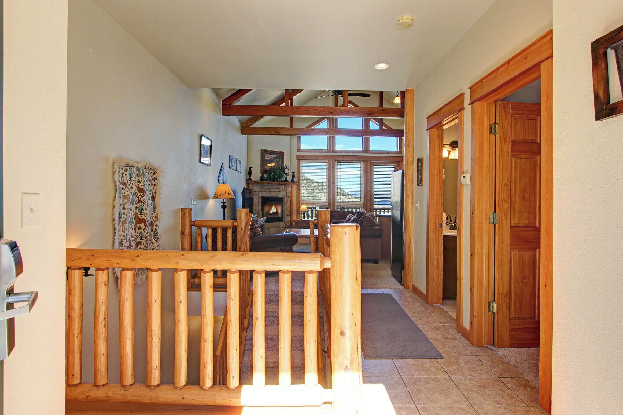 A spacious hallway with wooden beams, a fireplace, and a dining area with a table and chairs.