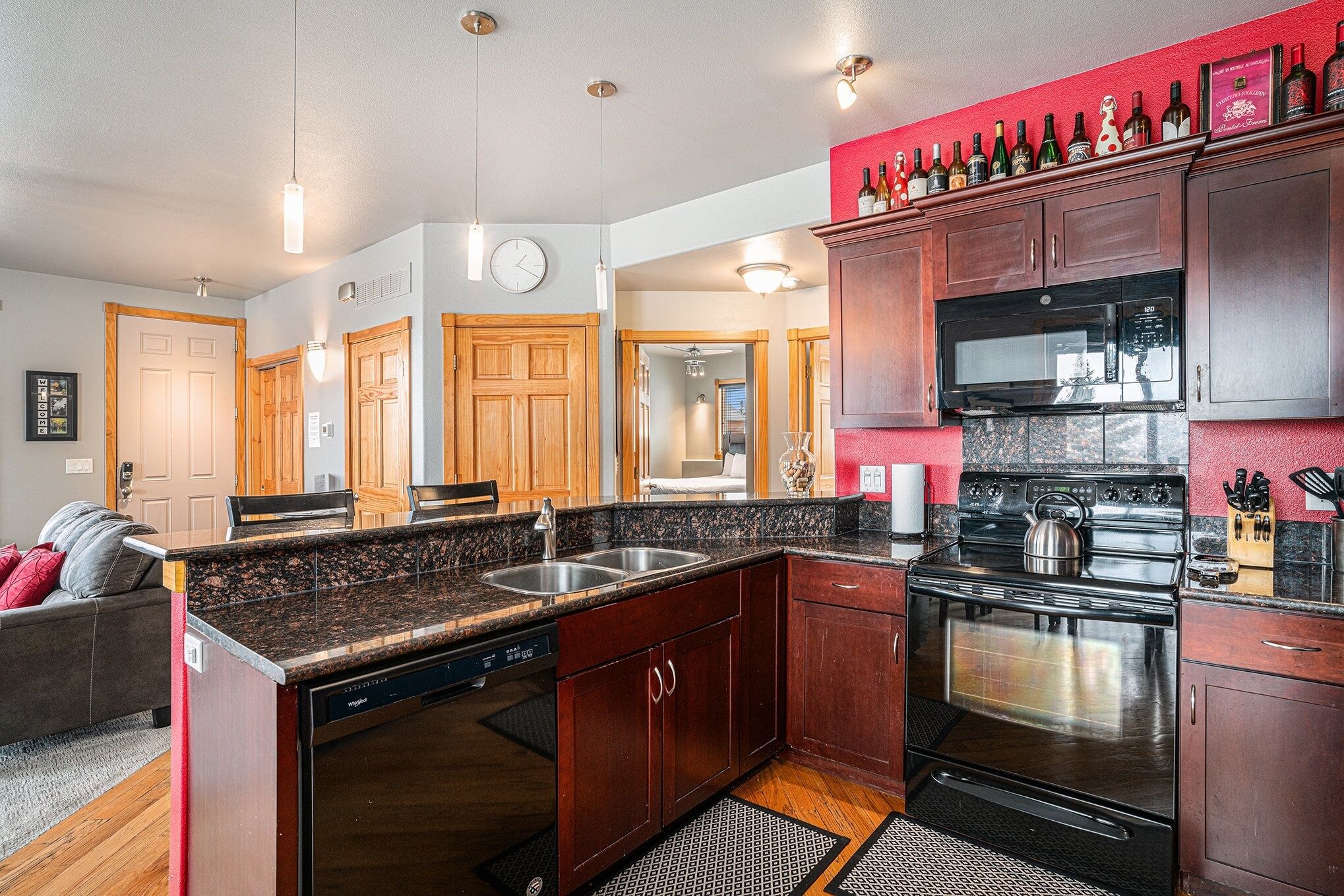 A modern kitchen with granite countertops, stainless steel appliances, and wooden cabinets.