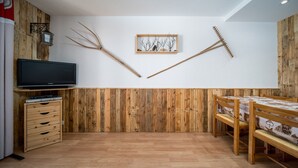 A room with wooden panel walls, a wooden bed, a TV on a stand, and a small cabinet.