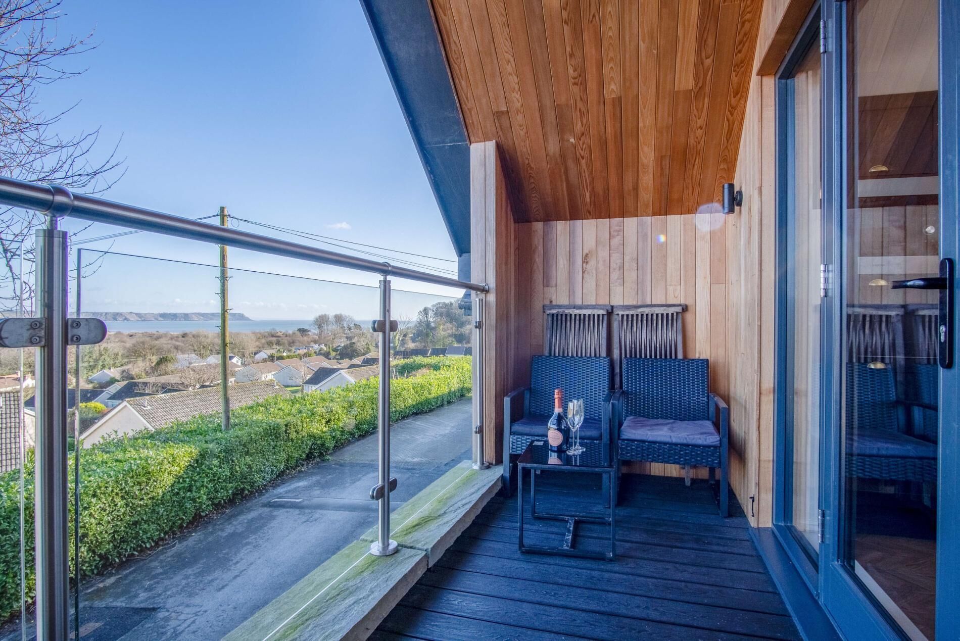 Un balcon donnant sur un paysage côtier, aménagé avec deux chaises et une petite table.