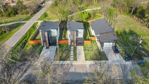 Ein modernes, zweistöckiges Haus mit Garage, Auffahrt und umzäunter Garten.