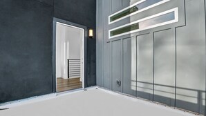 Ein moderner Gebäudeeingang mit Tür, einer Lampe und einem Fenster mit Jalousien.