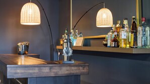 A bar area with two hanging lamps, a mirror, and various liquor bottles.