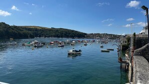 A harbor with boats docked, a clear sky, and a hillside in the background. - The Slipway Suite, Fowey Harbour & Parking 1 Min (Fowey)