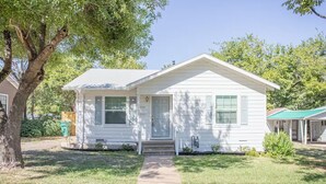 A single-story house with a front porch, a visible mailbox, and a number '208' on the door.