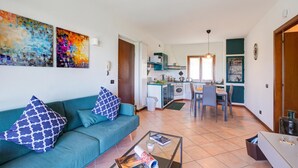 Un salon moderne avec un canapé de couleur turquoise, une table basse et deux tableaux abstraits.