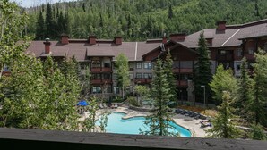 Un complexe hôtelier doté d’une piscine, de plusieurs bâtiments et surplombant une montagne boisée.