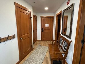 Stylish hallway with a bench and mirror, featuring a patterned rug.