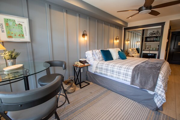 A modern bedroom with a bed, bedside table, lamp, chair, and a map on the wall. - 1311A - Two Bedroom Deluxe Eagle Springs West 2 Condo (Solitude)