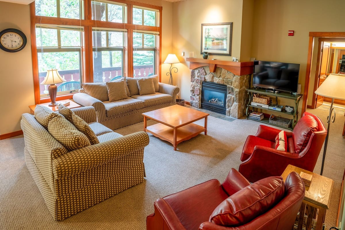 A cozy living room with a fireplace, a television, and comfortable seating.