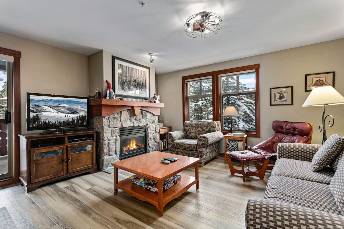 A cozy living room with a fireplace, a television, and comfortable seating.