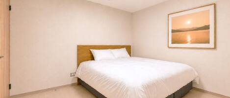 A bedroom with a single bed, a wooden headboard, a wall-mounted picture, and a light switch on the wall.