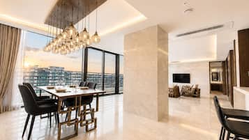Un interior moderno con comedor, sala de estar y un amplio ventanal con vistas a la ciudad.