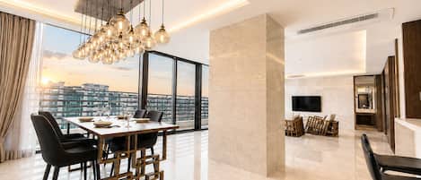 A modern interior with a dining area, a living space, and a large window offering a city view.
