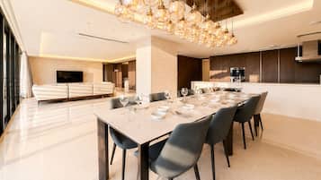 A modern dining area with a marble table set for six, surrounded by chairs.
