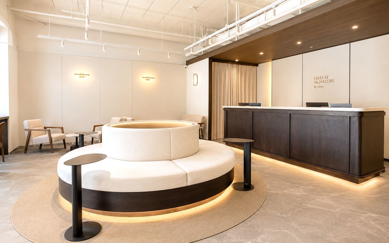A modern reception area with a circular seating arrangement, a reception desk, and a wall-mounted sign.