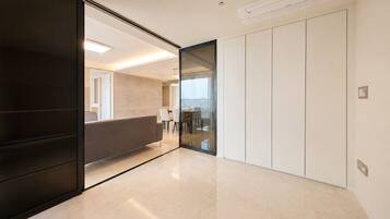 A modern interior with a sliding door leading to a dining area, a flat-screen TV, and a built-in air conditioning unit.