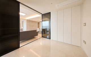 Un interior moderno con una puerta corredera que da a un comedor, un televisor de pantalla plana y un equipo de aire acondicionado integrado.