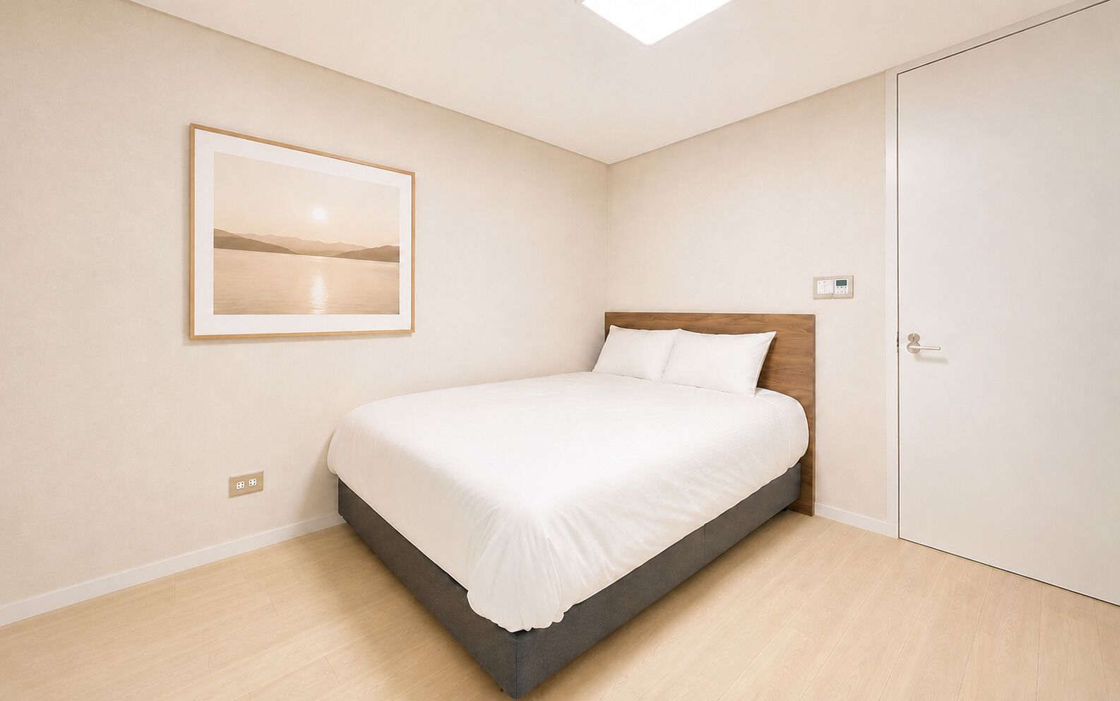 Un dormitorio con una cama, un cuadro en la pared y una puerta.