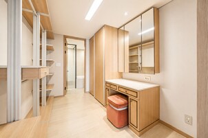 A modern bathroom with a wooden vanity, a mirror, and a shower area.