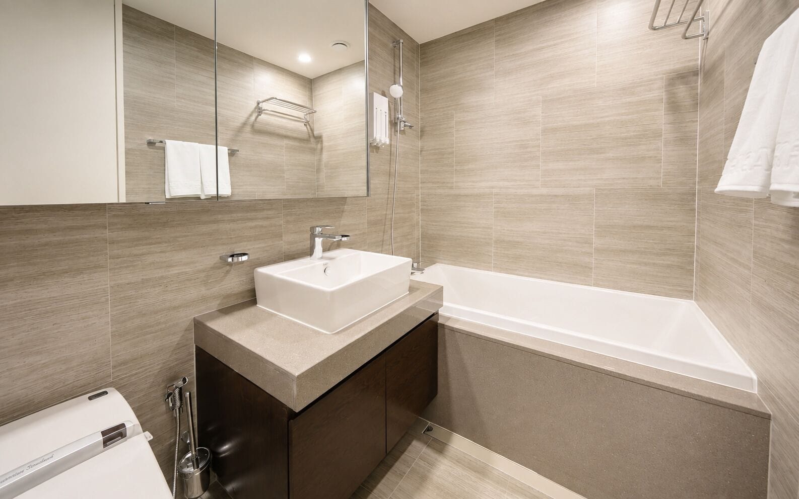 Un baño moderno con un lavamanos rectangular, una bañera y una zona de ducha.