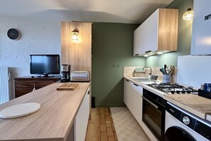 A compact kitchen with a wooden countertop, a gas stove, a washing machine, and a coffee maker. - Jardin sur Baie, 4-person ground-floor apartment with sea view (Le Crotoy)