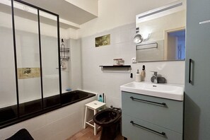 Un baño con bañera, inodoro, lavabo y espejo.