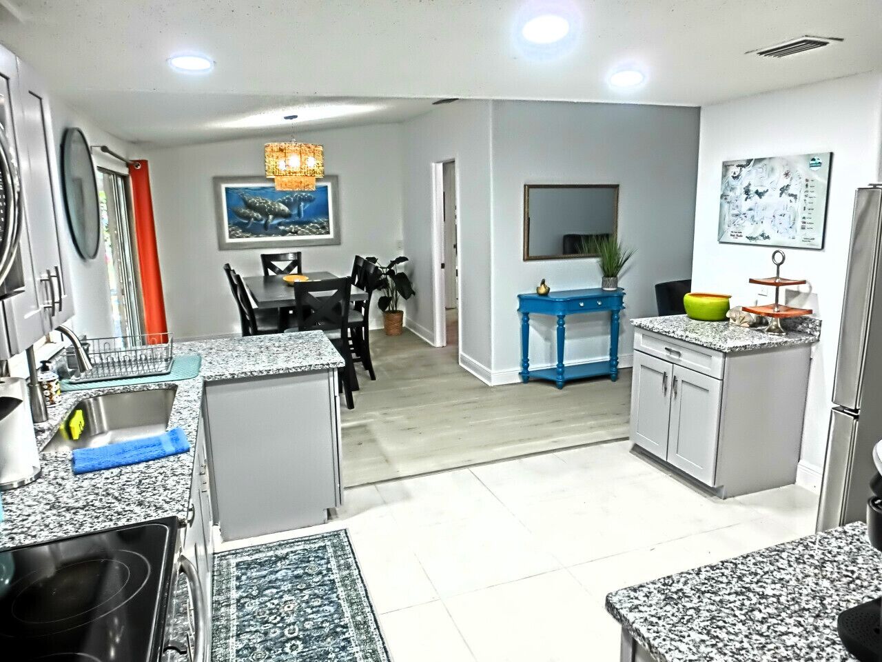 A kitchen with granite countertops, a dining area with a table and chairs, and a small island with a sink.