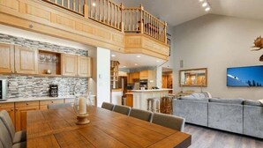 A spacious kitchen with a stone backsplash, wooden cabinets, and a dining area with a wooden table and chairs. - Beaver Creek Resort CO - Townsend Place & Strawberry Park Condos (Avon)