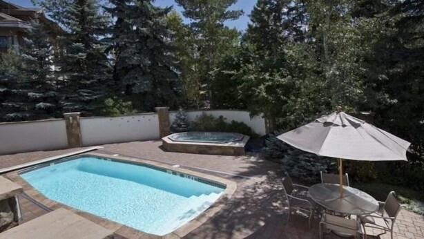 A backyard with a swimming pool, hot tub, and patio furniture. - Vail Ski Resort - Luxury Condos (Vail)