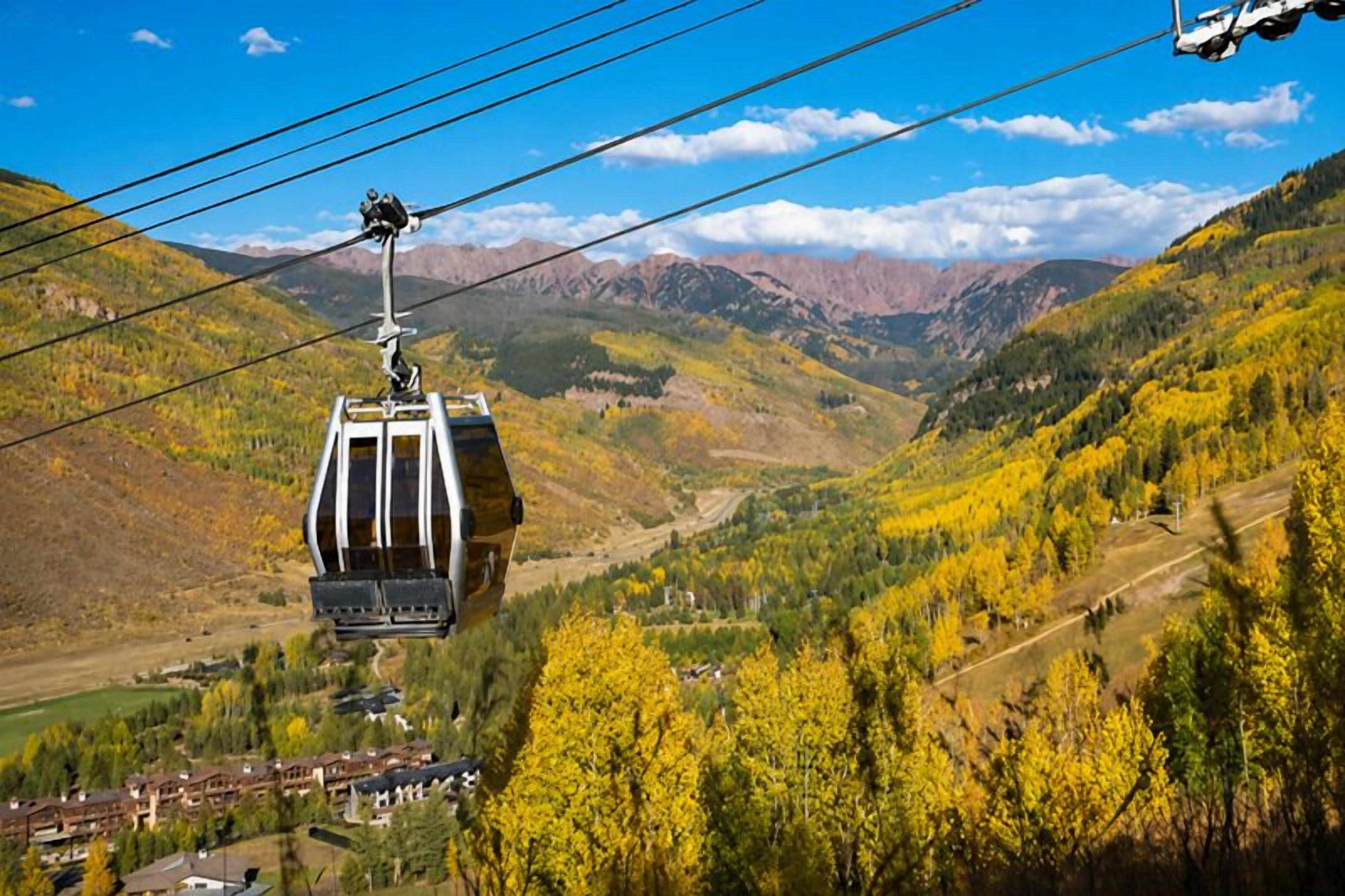 A cable car in a mountainous area with a valley below.