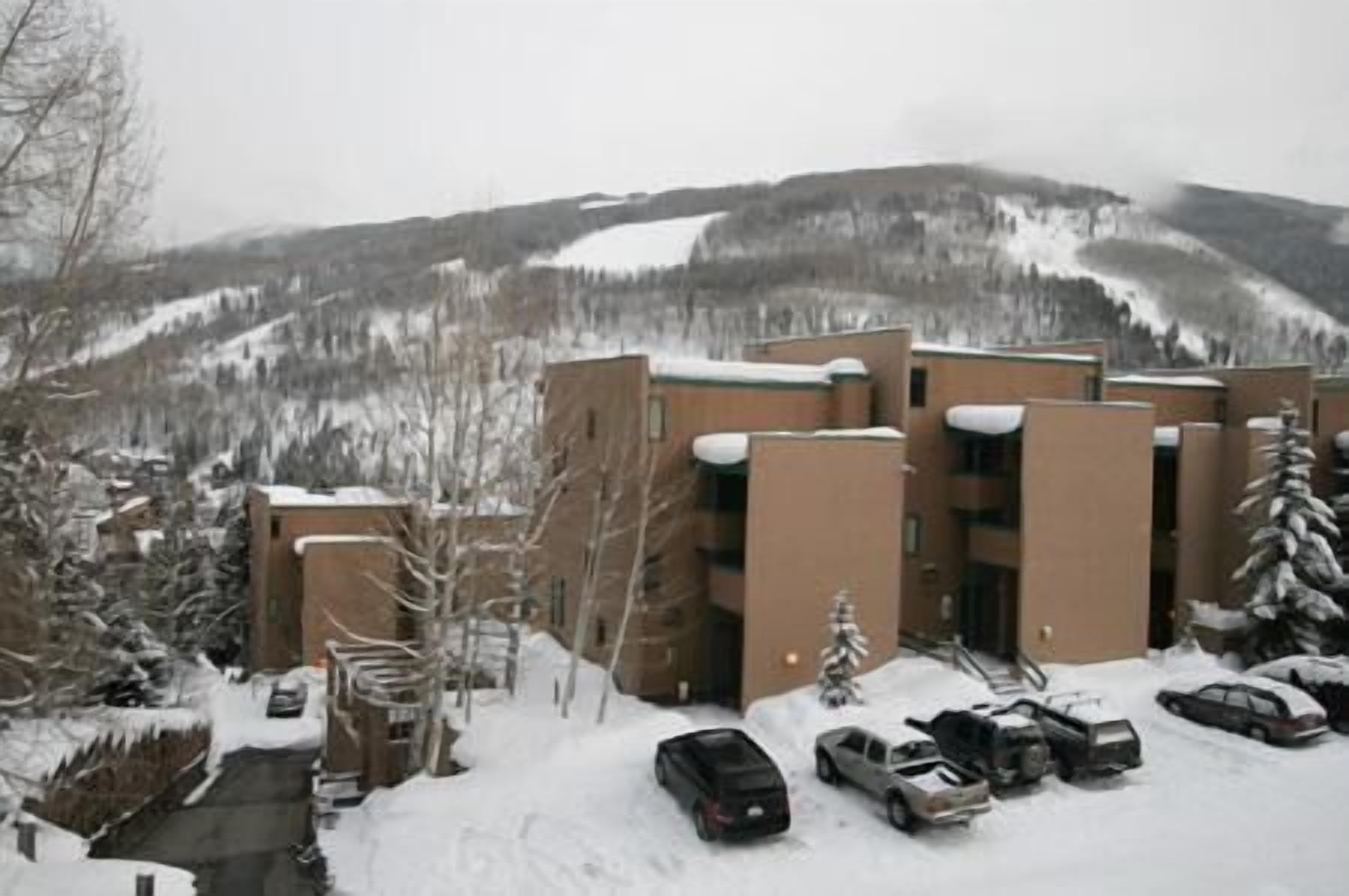A building with a parking lot and snow-covered surroundings.