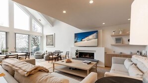 A modern living room with a fireplace, large windows, and a cozy seating area. - Vail Ski Resort Northwoods Condos (Vail)