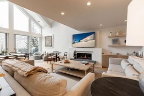 A modern living room with a fireplace, large windows, and a cozy seating area. - Vail Ski Resort Northwoods Condos (Vail)