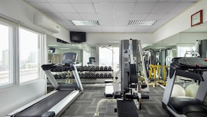 Una palestra con tapis roulant, manubri e macchinari per esercizi.
